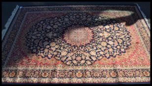 A Persian Islamic blue ground Keshan rug with floral patterning having a central medallion and red