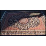 A Persian Islamic blue ground Keshan rug with floral patterning having a central medallion and red