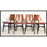 A set of 4 mid century teak wood G-Plan dining chairs being raised on ebonised Librenza style legs