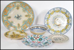 A collection of Faience ware pottery chargers and bowls to include Iznik ware, Italian etc. Measures