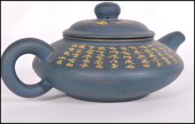 A Chinese Yi Xing teapot having a blue pottery ground with gilt Buddhist Scriptures and
