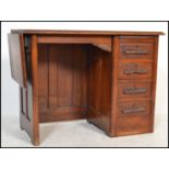 A 1920's oak childs Industrial style clerks desk with drop leaf to side, open kneehole recess