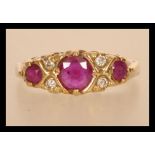 A hallmarked 9ct gold ruby and diamond ring having three rubies with diamond spacers.  Hallmarked