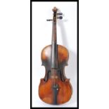 A late 19th century violin having a one piece maple back and spruce front. Shaped hollow body with