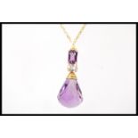 An 18ct gold pendant necklace having a large facted amethyst pendant drop with a smaller oval cut