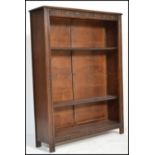A Victorian antique style oak open window bookcase cabinet having carved details to the sides with