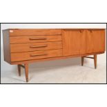 A 1970's Danish influence teak wood credenza sideboard raised on tapering legs having a bank of 4
