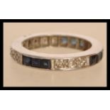 A white gold eternity ring set with square blue sapphires and round cut diamonds. Size K.5. Weight