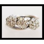 An 18ct white gold triple cluster crossover ring h