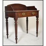 A Victorian 19th century solid mahogany writing table desk being raised on turned, tapering legs