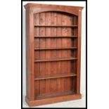 A large tall pine 6ft bookcase of upright form having a plinth base with central shelves and