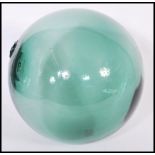 A 20th Century green glass witches ball / Japanese fishing float being of globular form with