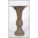 A 19th century Chinese bronze Gu vase of trumpet form raised on a circular base with Greek key and