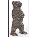 A 20th Century cast metal, cold painted money box, modelled as a Black forest bear standing on it'