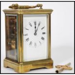 An early 20th century brass carriage clock having a white enamelled face and faceted hands, a