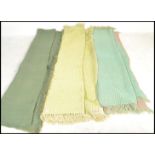 A collection of three vintage mid 20th Century waffle woollen blankets, each on light pastel