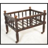 A 19th century Victorian mahogany spindle gallery cat bed having turned columns and railed tray