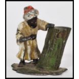 An early 20th century cold painted bronze miniature of an Arab man resting by a tree trunk. Measures