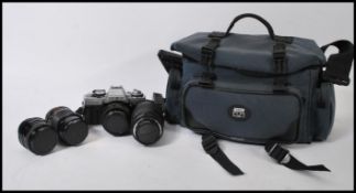 A vintage cased 35mm Minolta XG-M camera together with a Sigma UC 70-120mm Macro lens, Minolta MD