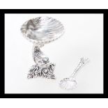 A silver salt in the form of a shell with a fish column and shell spoon. Weight 25.0g.