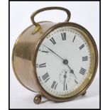 A 19th century Victorian brass alarm clock of round form with a white enamelled round face and roman