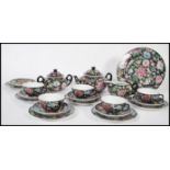A vintage 20th century Chinese enamel hand decorated tea service consisting of teapot, cup saucer