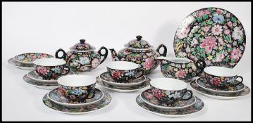 A vintage 20th century Chinese enamel hand decorated tea service consisting of teapot, cup saucer