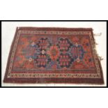 A vintage 20th Century floor rug / mat on red ground, central panel with geometric borders with