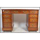 An Edwardian mahogany twin pedestal office desk being raised on squared plinth bases to each