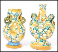 A near pair of vintage 20th century decorative Faience vases raised on circular bases with hoop