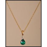 A hallmarked 9ct gold necklace chain having a 9ct gold diamond and green stone pendant. Weighs 2.5
