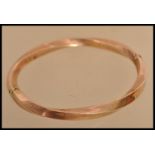 A 9ct gold bangle bracelet of twist form having a hidden clasp. Weighs 13 grams.