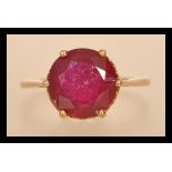 A 20th century stamped 375 gold yellow metal ring with a brilliant cut ruby in a prong and heart