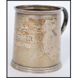 An early 20th century silver hallmarked tankard raised on a stepped circular base with shaped