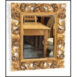 A vintage Florentine gilt wood framed wall mirror with shell and acanthus carved decoration, with