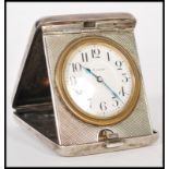 A silver 900 stamped travelling pocket watch clock having an engine turned case. The white enamel