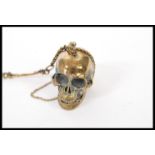 A gentleman's brass albert watch chain having an articulated skull and and skeleton detailing.