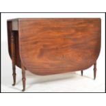 A good 19th century George III solid mahogany drop leaf / gateleg dining table being raised on