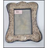An early 20th century silver hallmarked picture frame having embossed scrolls leaves and cherubs.
