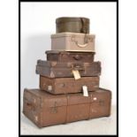 A stack of vintage suitcases to include canvas and wooden bound trunk, leather style suitcases,