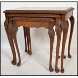 A vintage 20th century carved walnut nest of three side occasional tables raised on cabriole legs