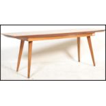 A mid century retro teak wood ' surfboard ' style coffee - occasional table. Raised on turned and