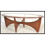 A retro teak wood atomic ' Astro ' oval coffee table by G Plan, having a drop centre glass panel,