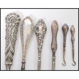 A selection of 20th century silver handled steel button hooks also including a late 19th century