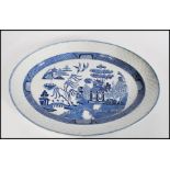 A 19th century Chinese blue and white willow pattern meat platter of large form having woven