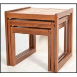 A set of three retro 20th Century tile topped teak wood neat of tables, each nest set with four