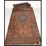A vintage 20th Century floor rug / mat / runner on red ground, central panel with geometric