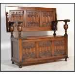 A good Jacobean revival oak monks bench settle table with fold down top and blue cushion flanked