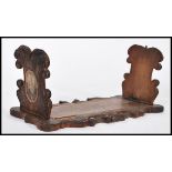 A 19th century Victorian carved wooden Blackforest book trough / slide having scrolled decoration