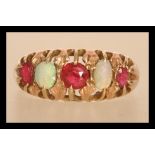 A 9ct gold opal and pink stone ring having alternating faceted pink stones and opal cabochons.